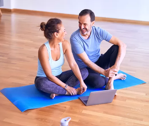 Couple on yoga mat with laptop